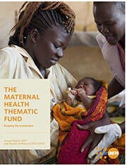 Photo of midwife handing a new mother her newborn